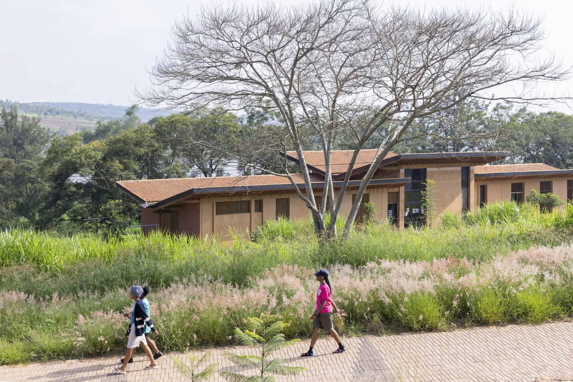 Exterior of a building on the RICA campus with two people walking past it.