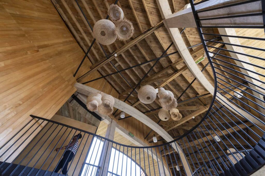 Interior ceiling of building on RICA campus with baskets hanging from wooden shafts.